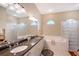 Well-lit bathroom with double sinks, granite countertops, and a glass block shower for a modern touch at 7464 Ridge Rd, Sarasota, FL 34238