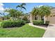 Charming home featuring a well-manicured lawn, lush landscaping, and a spacious three-car garage at 7464 Ridge Rd, Sarasota, FL 34238