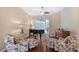 Bright living room with hardwood floors, piano, and sliding glass doors to the patio at 7464 Ridge Rd, Sarasota, FL 34238