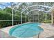 Screened pool with light turquoise water and stone pavers surrounded by lush tropical foliage at 7464 Ridge Rd, Sarasota, FL 34238