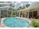 Outdoor living area with a screened pool, outdoor kitchen, and comfortable seating area at 7464 Ridge Rd, Sarasota, FL 34238