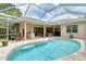 The screened-in pool is surrounded by a stone patio and outdoor kitchen at 7464 Ridge Rd, Sarasota, FL 34238
