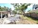 View of the driveway leading to a house with wood siding and a covered parking area behind a gated fence at 809 30Th E Ave, Bradenton, FL 34208