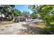 View of the driveway leading to a house with wood siding and a covered parking area behind a gated fence at 809 30Th E Ave, Bradenton, FL 34208
