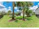 Landscaped backyard featuring a screened patio, fire pit, trampoline, black fence, and well-maintained lawn at 8721 Firefly Pl, Parrish, FL 34219