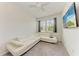Cozy bedroom features plush carpeting, white sectional couch, and mounted TV at 8721 Firefly Pl, Parrish, FL 34219
