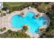 Aerial view of a large community pool with lounge chairs and umbrellas surrounded by lush landscaping at 8721 Firefly Pl, Parrish, FL 34219