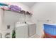 Functional laundry room with washer, dryer, and shelving for storage at 8721 Firefly Pl, Parrish, FL 34219