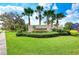 Summerwoods community entrance sign featuring lush landscaping, palm trees, and a well-maintained lawn at 8721 Firefly Pl, Parrish, FL 34219