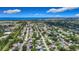 Wide aerial view of the coastal neighborhood with lush greenery and the ocean visible in the distance under a blue sky at 912 Ponderosa Pine Ln, Sarasota, FL 34243