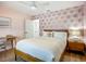 Stylish bedroom featuring a ceiling fan, pink walls with palm tree accents, and a wooden bed frame at 912 Ponderosa Pine Ln, Sarasota, FL 34243
