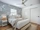 Serene bedroom with patterned wallpaper, white sliding closet doors, and a ceiling fan for optimal comfort at 912 Ponderosa Pine Ln, Sarasota, FL 34243