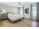Bedroom with wood floors, ceiling fan, and leafy wallpaper at 912 Ponderosa Pine Ln, Sarasota, FL 34243