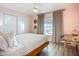 Inviting bedroom with a ceiling fan, pink walls, wooden bed frame, and a window providing natural light at 912 Ponderosa Pine Ln, Sarasota, FL 34243
