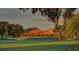 Sprawling clubhouse with a red tiled roof, surrounded by lush greenery and mature trees at 912 Ponderosa Pine Ln, Sarasota, FL 34243