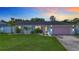 Charming single-story home with a well-manicured lawn, pink garage door, and tasteful landscaping at 912 Ponderosa Pine Ln, Sarasota, FL 34243