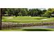 Picturesque golf course view with a water hazard and manicured green, framed by mature trees at 912 Ponderosa Pine Ln, Sarasota, FL 34243