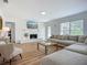 Bright living room features a stone fireplace, large window, and comfortable sectional sofa at 912 Ponderosa Pine Ln, Sarasota, FL 34243