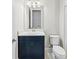 Bathroom with a blue vanity, white countertop, toilet, and mirror, offering a fresh and modern feel at 10309 Longmeadow Ave, Parrish, FL 34219