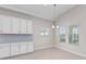 Dining area featuring white cabinetry, modern lighting, and windows that offer ample natural light and exterior views at 10309 Longmeadow Ave, Parrish, FL 34219
