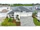 Stunning home exterior featuring a three-car garage, elegant landscaping, and a serene lake view at 10309 Longmeadow Ave, Parrish, FL 34219