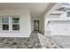 Inviting entryway with patterned pavers, a stylish front door, and an attached two-car garage at 10309 Longmeadow Ave, Parrish, FL 34219