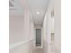 A well-lit hallway with neutral walls and recessed lighting, leading to various rooms in the home at 10309 Longmeadow Ave, Parrish, FL 34219