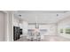 Well-lit kitchen featuring modern stainless steel appliances, white cabinetry, a central island with seating, and ample counter space at 10309 Longmeadow Ave, Parrish, FL 34219
