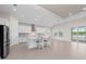 Spacious kitchen with modern appliances, a large island with seating, and sliding glass doors that lead to the outdoor pool area at 10309 Longmeadow Ave, Parrish, FL 34219