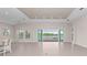 Bright and airy living room with tile floors, recessed lighting, and sliding glass doors leading to the pool at 10309 Longmeadow Ave, Parrish, FL 34219