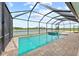 A screened-in pool and spa offer picturesque views of the lake, perfect for relaxation at 10309 Longmeadow Ave, Parrish, FL 34219