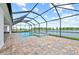 Relax by the pool and spa with tranquil lake views from this screened-in brick-paved lanai at 10309 Longmeadow Ave, Parrish, FL 34219