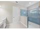 Close-up of a glass-enclosed shower with blue tile and built-in shelving at 10309 Longmeadow Ave, Parrish, FL 34219