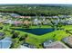 Beautiful aerial view of homes surrounding a pond with lush green lawns and mature trees at 11915 Oak Ridge Dr, Parrish, FL 34219