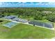 Aerial view of tennis and pickleball courts surrounded by lush greenery and mature trees at 11915 Oak Ridge Dr, Parrish, FL 34219