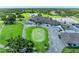 Beautiful aerial showcasing the clubhouse, golf course, and adjacent parking, seamlessly blending recreation and convenience at 11915 Oak Ridge Dr, Parrish, FL 34219