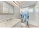 This bathroom features a granite countertop, tub/shower combo, and ample lighting at 11915 Oak Ridge Dr, Parrish, FL 34219