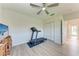This bedroom features a treadmill, ceiling fan, plank flooring, and closet for a tidy space at 11915 Oak Ridge Dr, Parrish, FL 34219