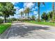 Picturesque entrance gate leading into the community with decorative columns, palm trees, and well-maintained landscaping at 11915 Oak Ridge Dr, Parrish, FL 34219