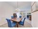 Bright dining room with hardwood floors, chandelier, and blue upholstered chairs at 11915 Oak Ridge Dr, Parrish, FL 34219