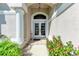 Elegant front entrance with double doors, decorative columns, and vibrant landscaping at 11915 Oak Ridge Dr, Parrish, FL 34219