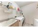 Functional laundry room featuring a washing machine, dryer, sink, and shelving for ample storage at 11915 Oak Ridge Dr, Parrish, FL 34219