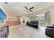 Open concept living room with sliding doors to the pool and a modern ceiling fan at 11915 Oak Ridge Dr, Parrish, FL 34219