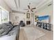 Comfortable living room featuring tray ceilings, a ceiling fan, and a cozy fireplace at 11915 Oak Ridge Dr, Parrish, FL 34219