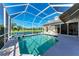 Beautiful pool with covered screened enclosure overlooking a lake, offering privacy and scenic views at 11915 Oak Ridge Dr, Parrish, FL 34219