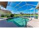Sparkling blue swimming pool in a screened lanai overlooking a scenic waterfront at 11915 Oak Ridge Dr, Parrish, FL 34219