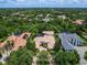 A beautiful aerial view of a home showcasing a well-maintained tile roof, surrounded by trees, and nestled in a desirable community at 12448 Highfield Cir, Lakewood Ranch, FL 34202