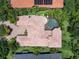 Expansive aerial view showcases a tile roof, screened in pool, lush greenery, and a brick driveway at 12448 Highfield Cir, Lakewood Ranch, FL 34202