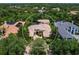 A high-angle capture of a stunning house featuring a tiled roof, manicured landscaping, and nestled among mature shade trees at 12448 Highfield Cir, Lakewood Ranch, FL 34202
