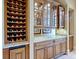 The bar area includes a wine refrigerator, lots of wine storage, and an upper cabinet with glass doors at 12448 Highfield Cir, Lakewood Ranch, FL 34202
